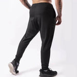 Person wearing black jogger pants on a white background